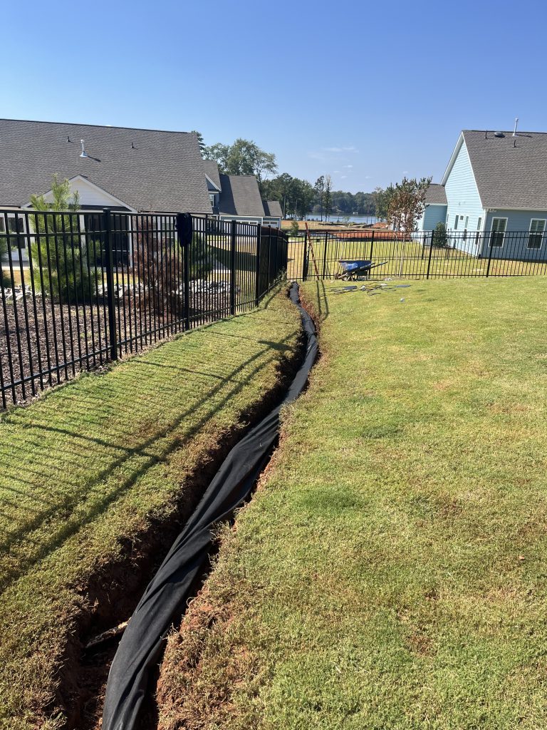 installing perforated pipe wrapped in protective fabric for french drain in lancaster sc