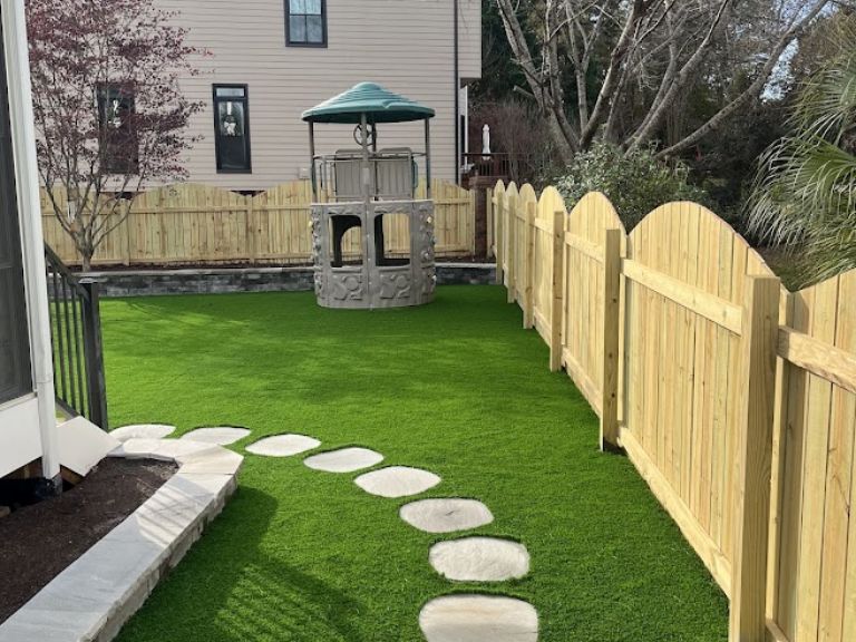 artificial-turf-walkway-installation-fort-mill-sc backyard walkway installation next to artificial turf in fort mill sc residential landscaping project