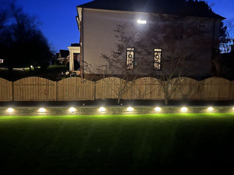stone-retaining-wall-integrated-lighting-fort-mill-sc backyard stone retaining wall with integrated custom outdoor lighting in fort mill sc landscaping project