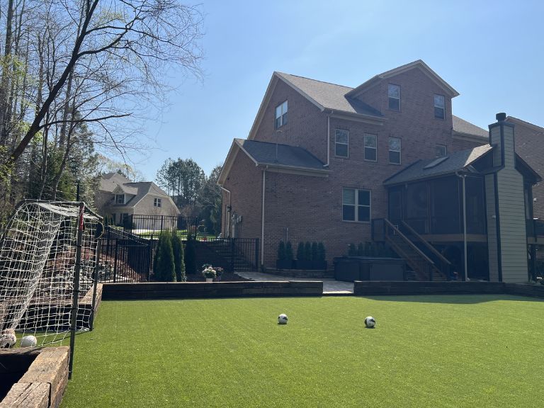 Mid-installation photo showing base layer and turf rollout at Carmel Commons Fort Mill SC — CLT Pros crew at work