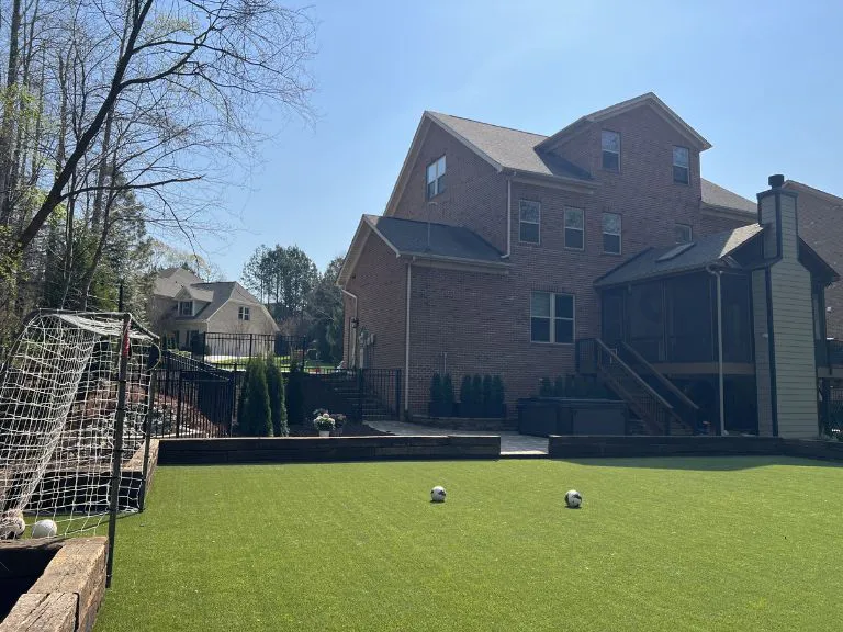 artificial turf soccer field with goal, block retaining wall border and brick home in fort mill, sc