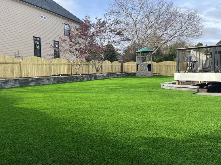 Backyard artificial turf and hardscape border detail at Providence Square Fort Mill SC — CLT Pros project