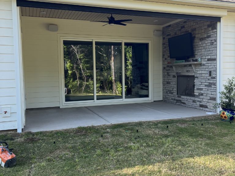 covered concrete patio with ceiling fan and stone accent wall before white marble installation in indian land, sc