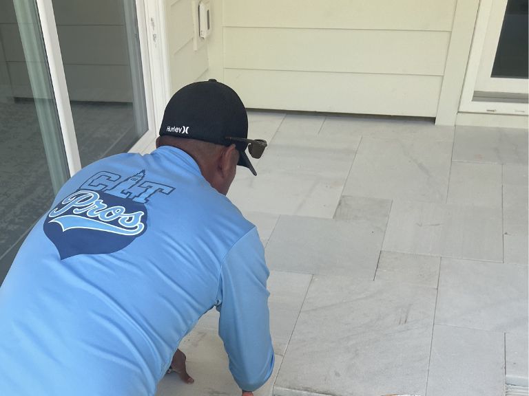 clt pros installer setting white marble pavers on a covered patio in indian land, sc