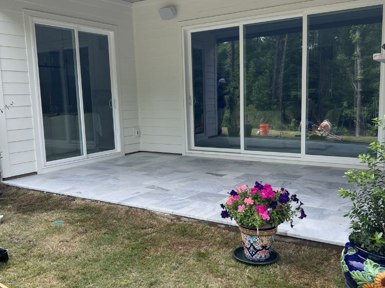 completed white marble covered patio seen from the lawn in indian land, sc