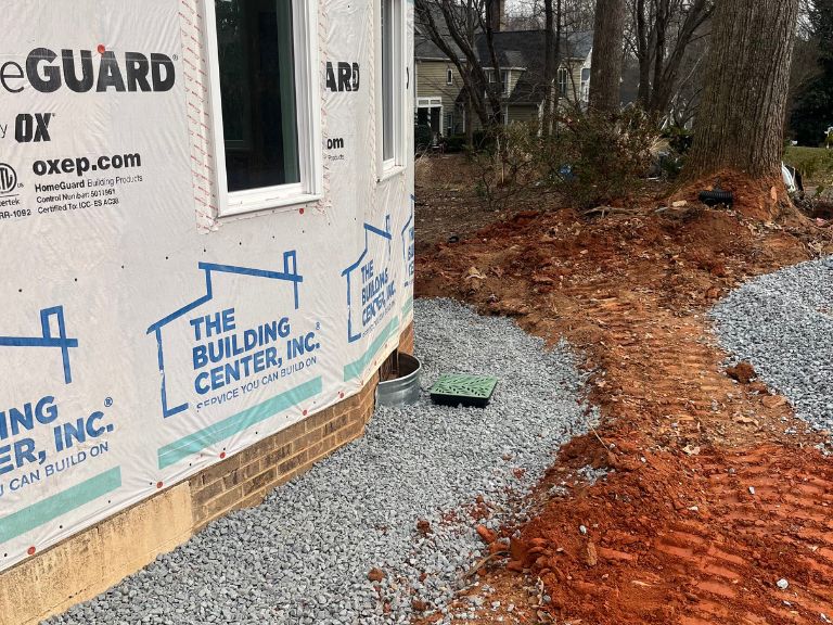 gravel drainage bed and catch basin installed along foundation in matthews, nc