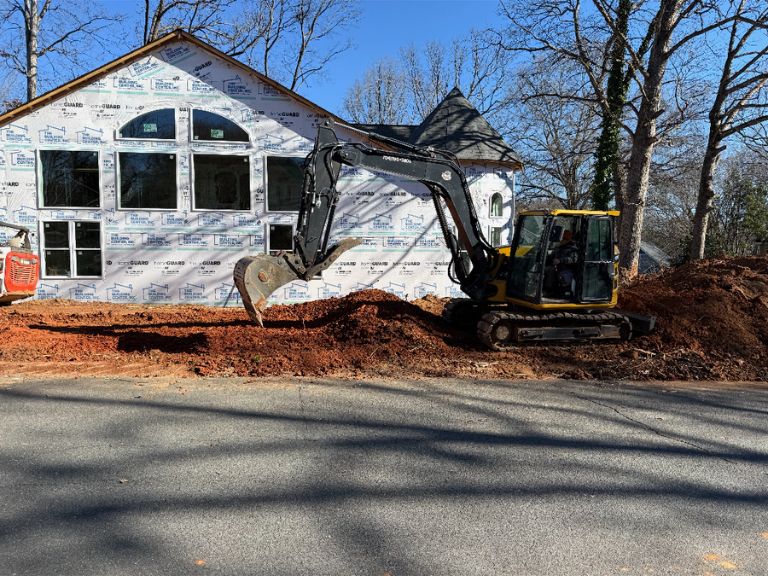 mini excavator finishing grading work near home foundation in matthews, nc