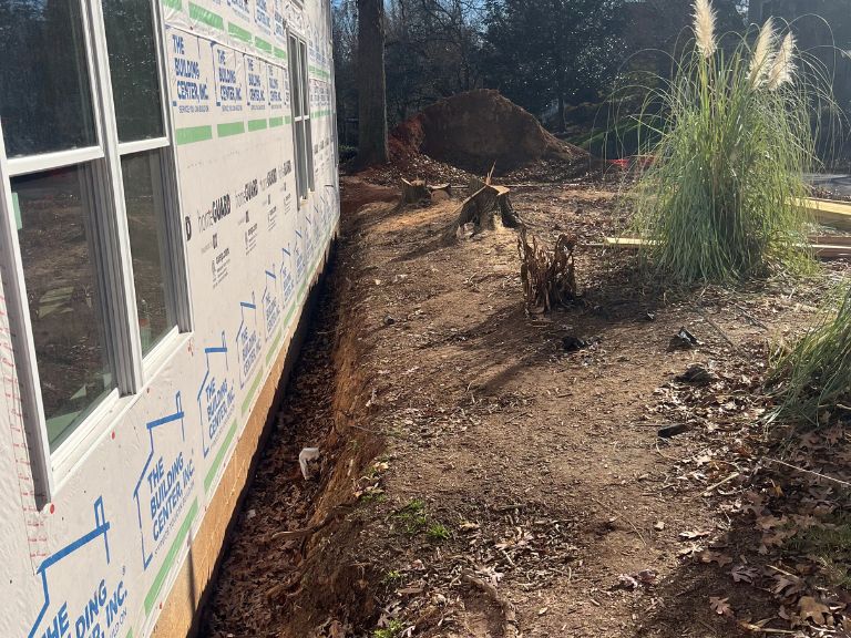 trench and eroded soil along home foundation before grading in matthews, nc