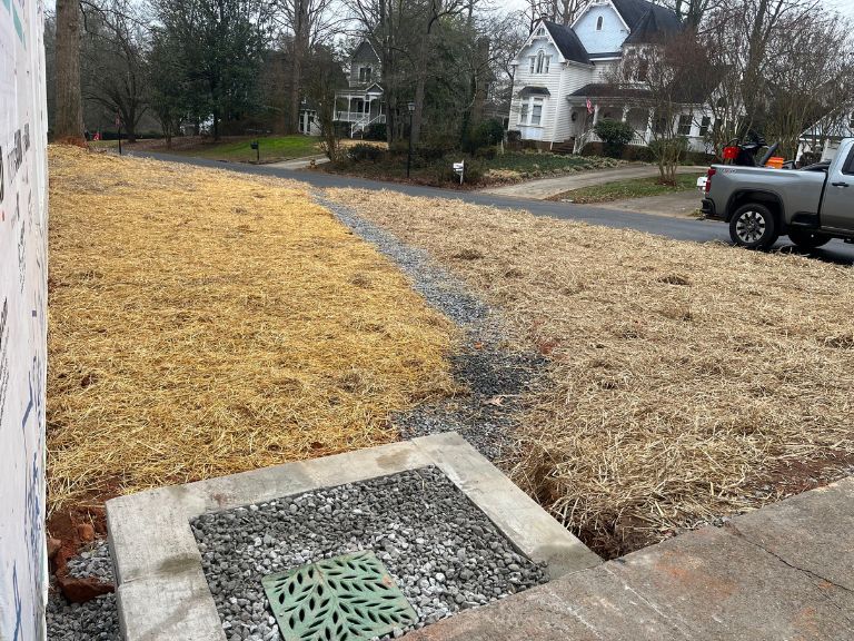finished grading with straw erosion cover and gravel drain strip to catch basin in matthews, nc
