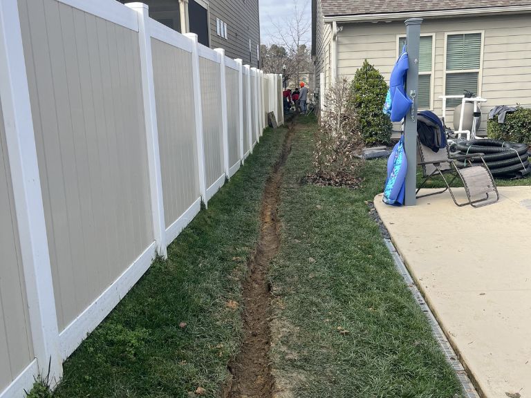 trench being dug for french drain installation in huntersville, nc backyard