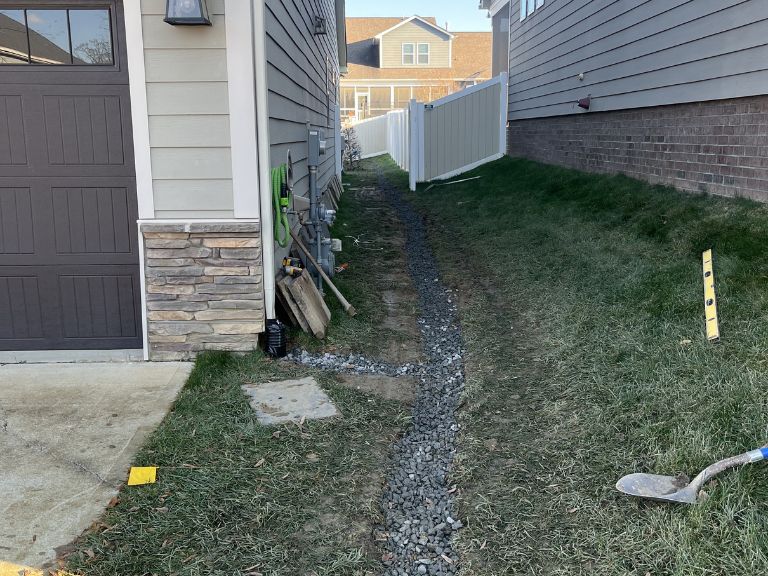 gravel backfill being added around french drain pipe in huntersville, nc