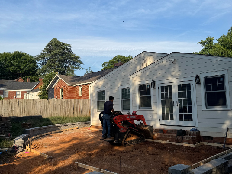 compact track loader excavating the backyard for a new patio and retaining wall in south end, charlotte, nc