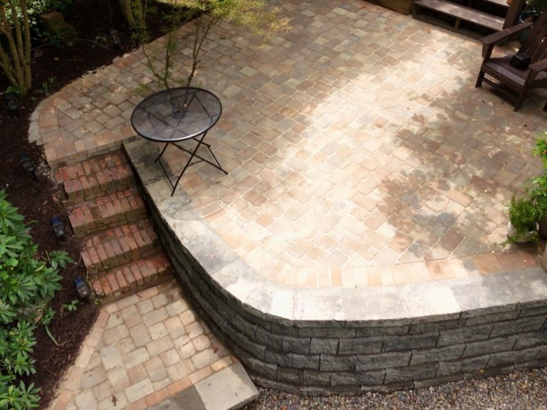 overhead view of multi-tone tumbled paver patio with curved retaining wall edge and step access to lower yard in plaza midwood charlotte nc