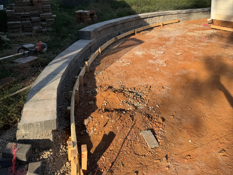 curved segmental block retaining wall going in around the graded patio base in south end, charlotte, nc