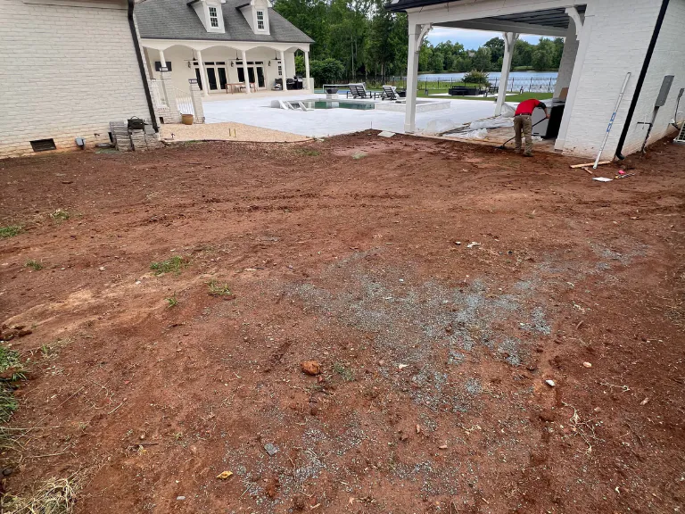 graded red clay backyard toward the pool house before artificial turf installation in weddington, nc