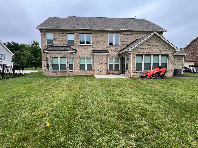 backyard lawn and brick home before paver patio construction in weddington, nc