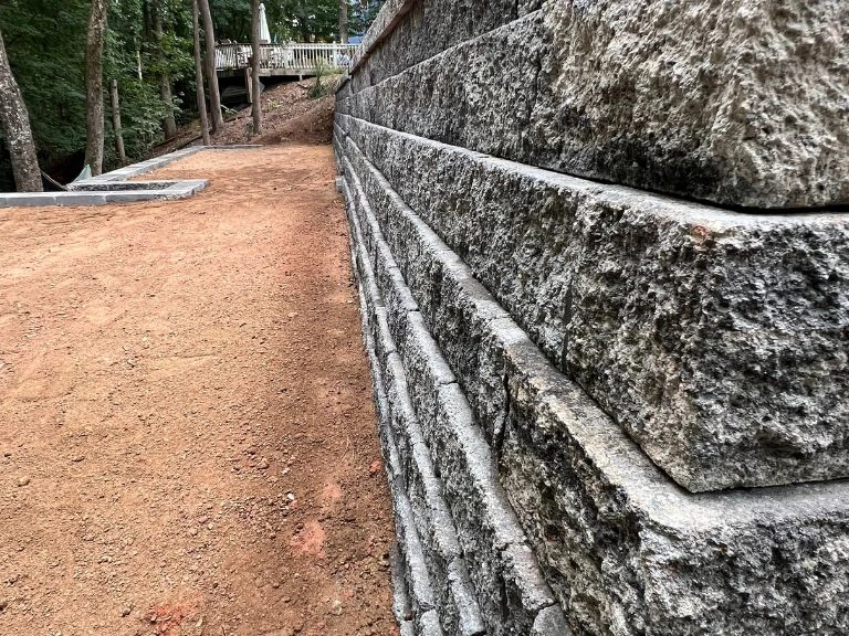 close-up profile of granite-face segmental block retaining wall along graded slope in tega cay sc — clt pros workmanship detail