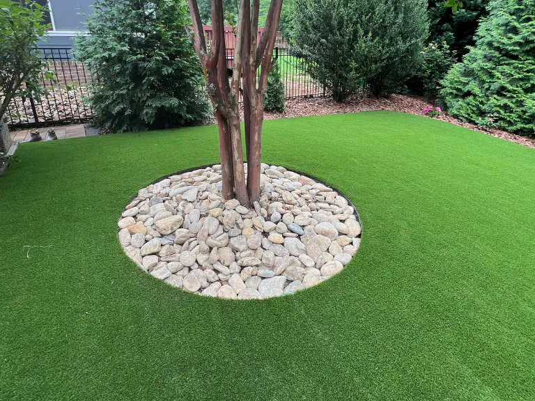river rock tree ring set into new artificial turf in a tega cay, sc backyard