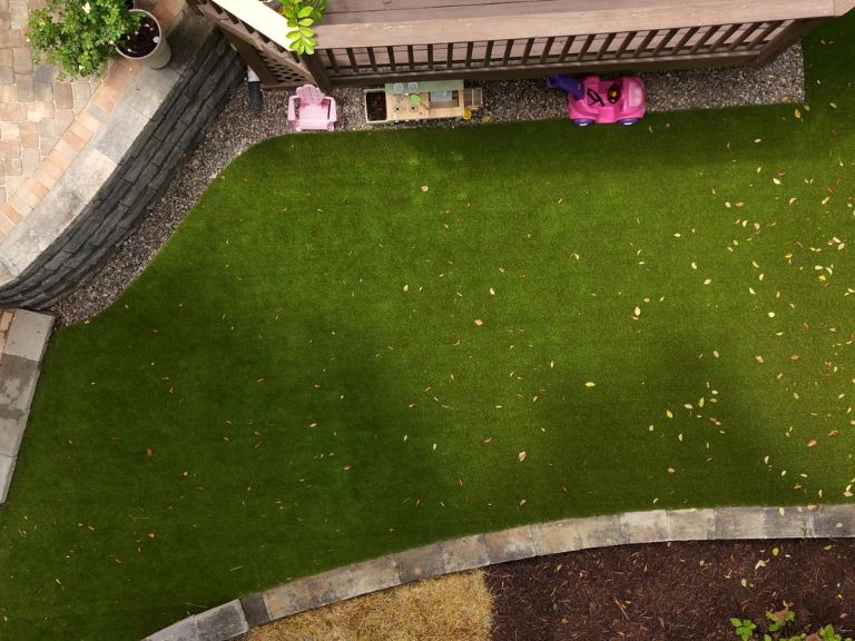 aerial overhead shot of artificial turf play area with pea gravel border and segmental block edging wall at plaza midwood charlotte nc — clt pros