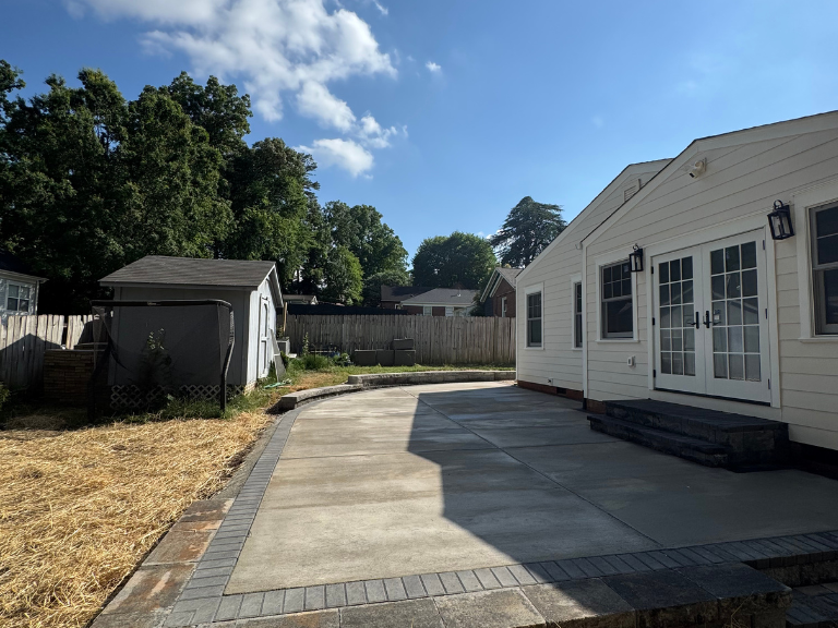 concrete patio and curved retaining wall behind the house toward the shed in south end, charlotte, nc