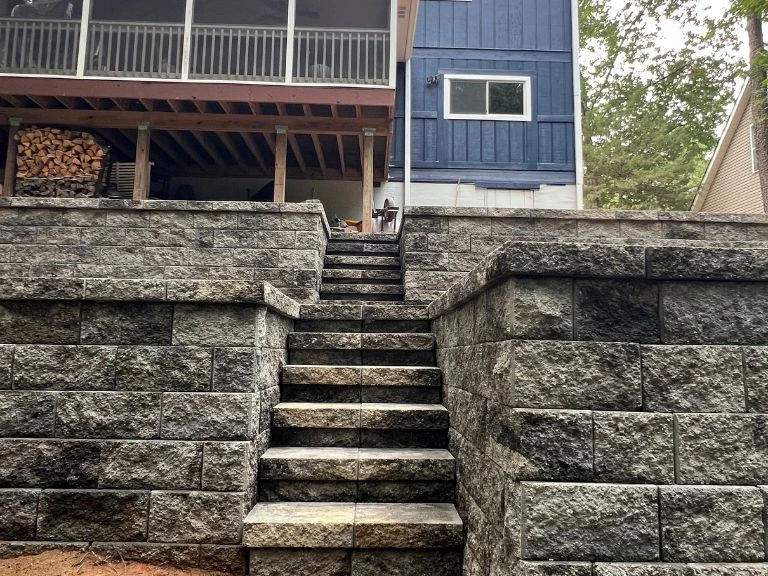 block stair case built into terraced retaining wall system leading up to screened porch in tega cay sc — clt pros