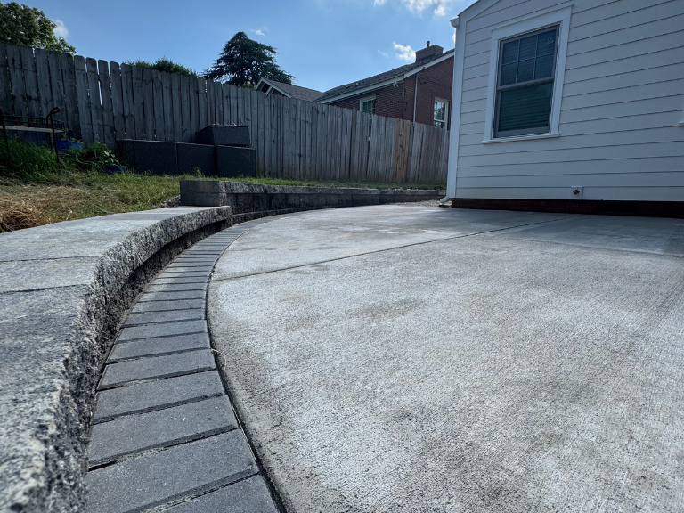 curved paver border and retaining wall cap along the edge of the concrete patio in south end, charlotte, nc