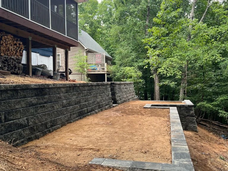 side view of terraced retaining wall graded level with paver border and wooded backdrop in tega cay sc — clt pros