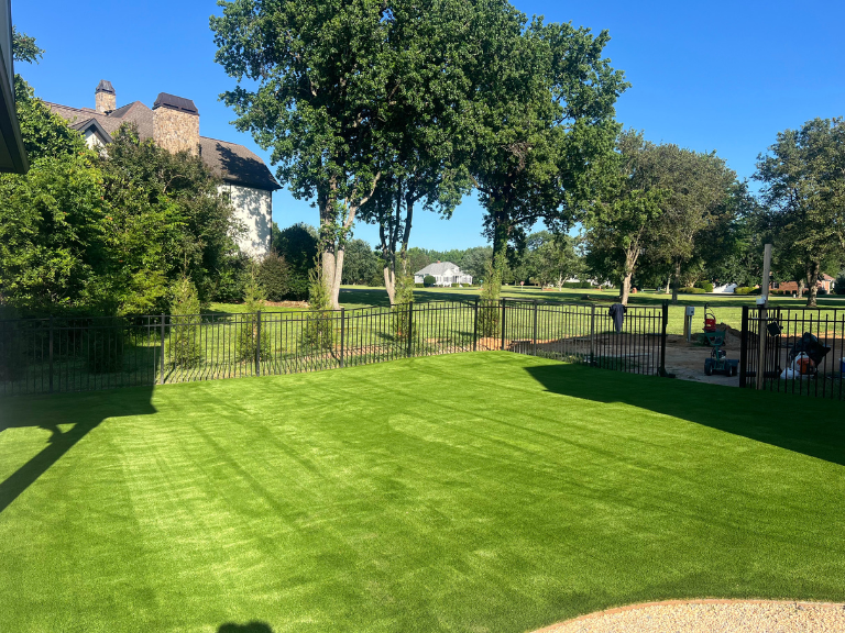 artificial turf backyard along a black iron fence with open views in weddington, nc