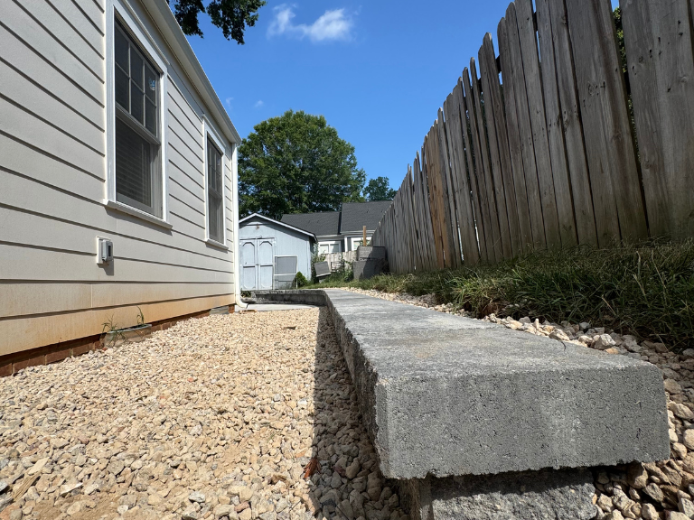 retaining wall cap along a gravel side yard and wood privacy fence in south end, charlotte, nc
