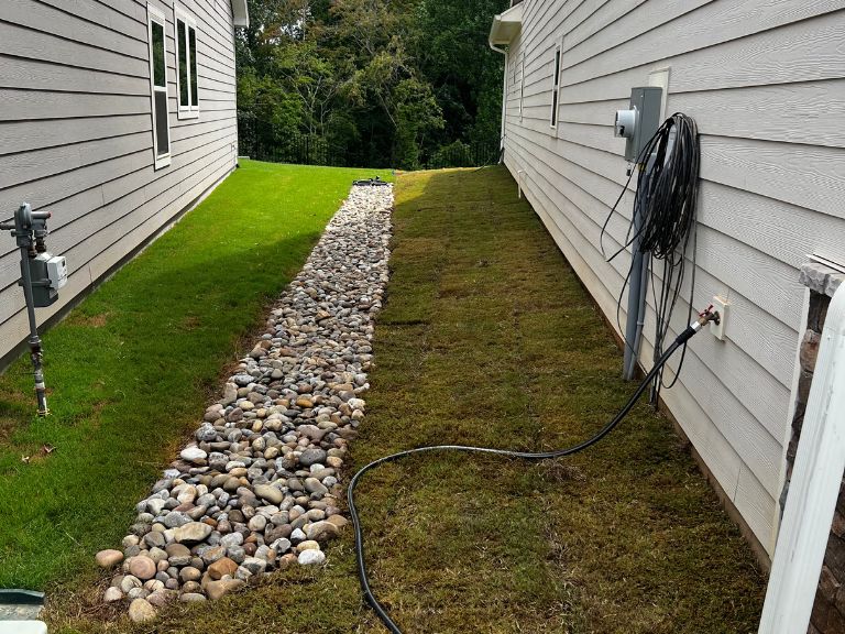New Bermuda sod and river rock drainage channel at Waxhaw NC home — CLT Pros Union County landscaping and drainage