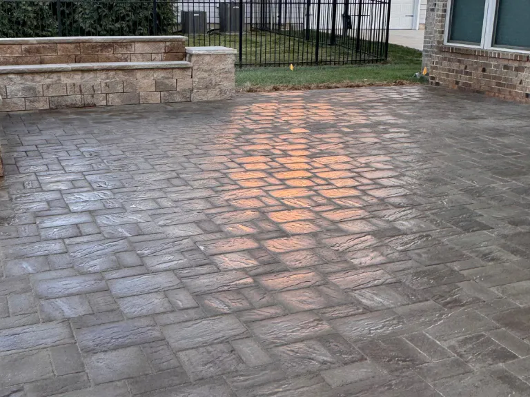 wet paver patio surface reflecting the porch light near the seating wall in weddington, nc