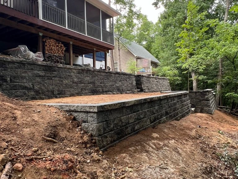 mid-construction view of two-tier terraced retaining wall with upper level graded and lower wall rising in tega cay sc — clt pros