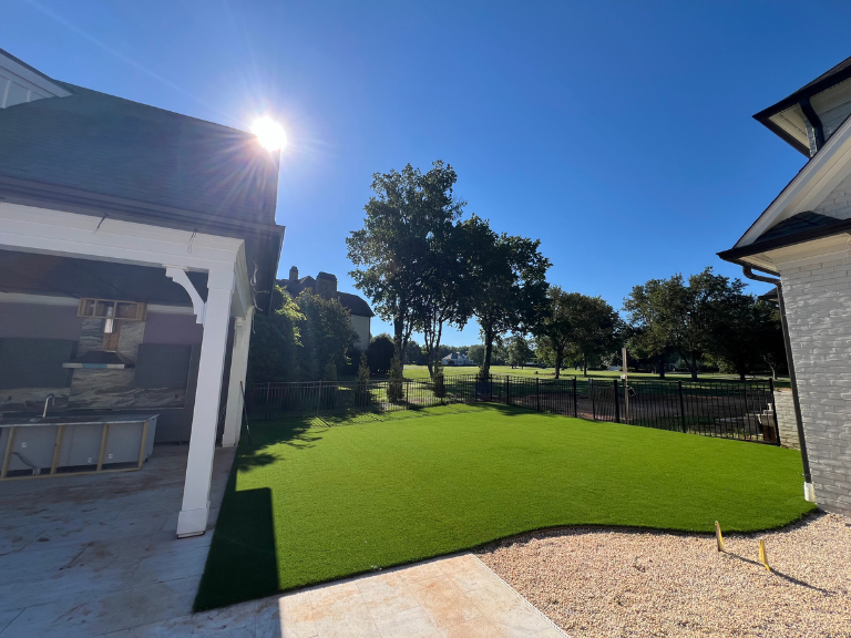 curved artificial turf edge meeting the covered patio and gravel border in weddington, nc