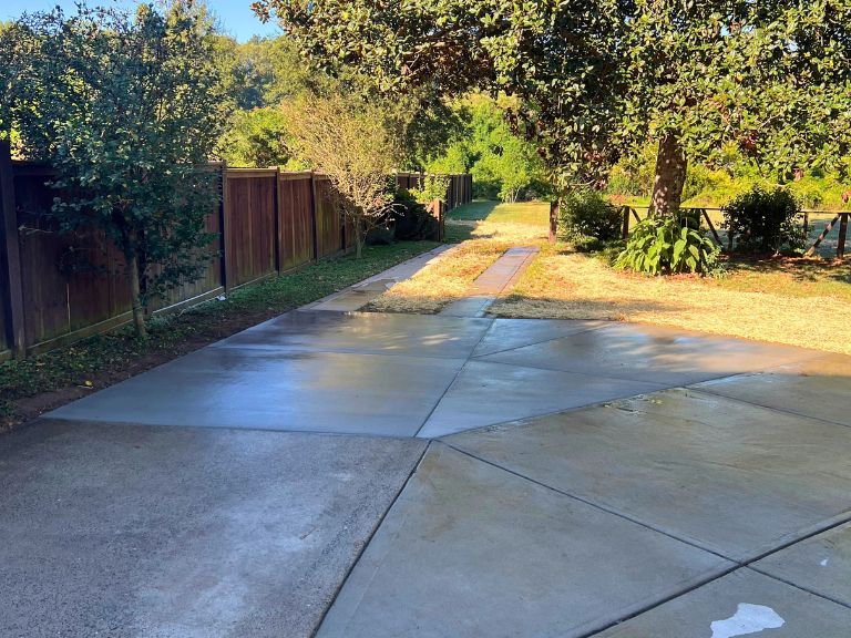 completed concrete parking and turnaround pad tapering into the backyard path in grier heights, charlotte, nc