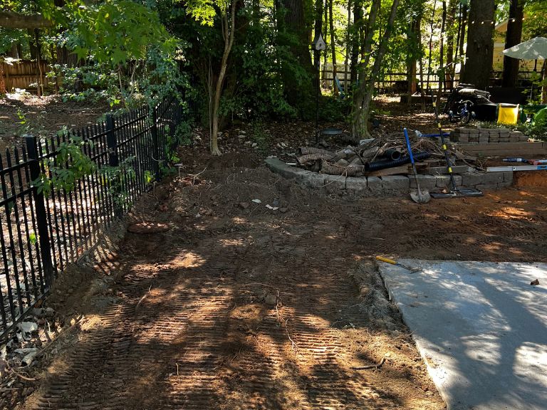 graded soil along the fence line beside the newly poured concrete slab in huntersville, nc