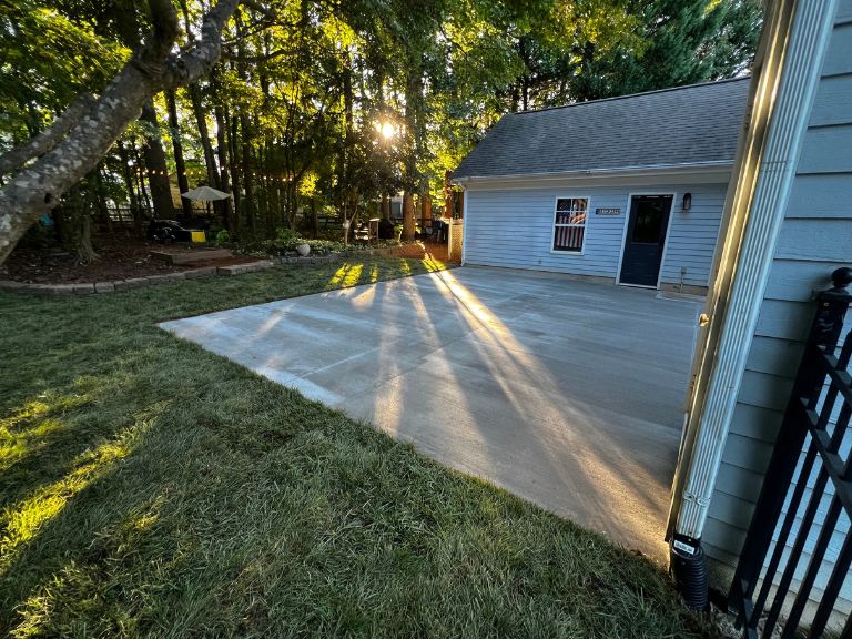 new concrete patio and tall fescue sod in late-afternoon sun facing the detached garage in huntersville, nc