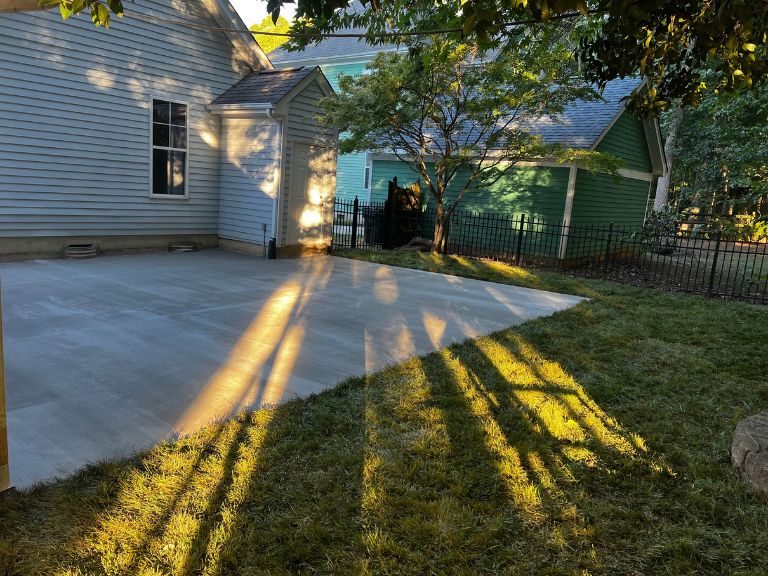 concrete patio with a new sod lawn edge along the corner of the house in huntersville, nc