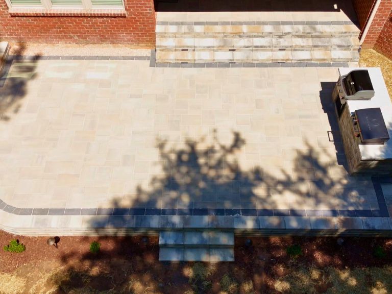 top-down aerial view of a curved raised paver patio, steps, and outdoor kitchen in indian land, sc