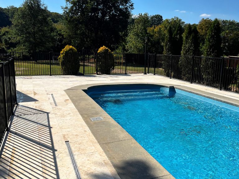 travertine pool deck with a linear channel drain and gray coping in grier heights, charlotte, nc
