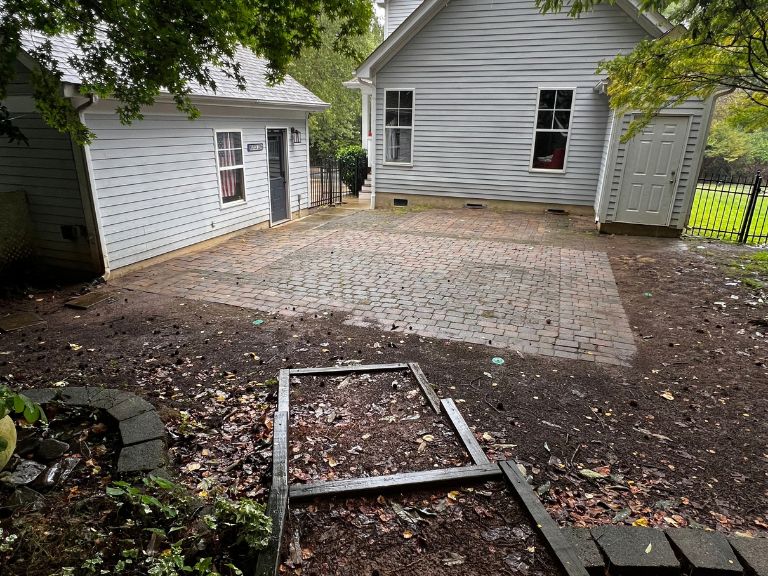 wide view of the old paver patio and broken timber bed frame before demolition in huntersville, nc