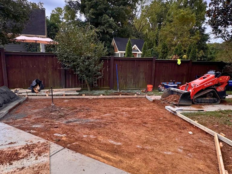 excavated driveway extension area with forms set and a compact track loader in grier heights, charlotte, nc