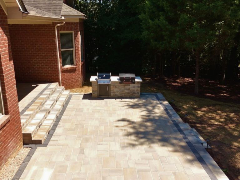 paver patio and outdoor kitchen against a wooded backyard in indian land, sc