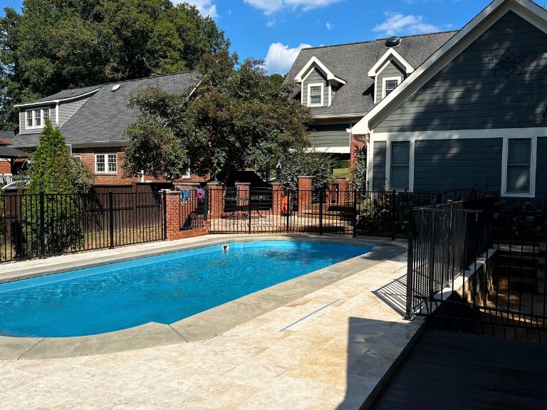 travertine pool deck and trex composite deck walkway beside the pool fence gate in grier heights, charlotte, nc