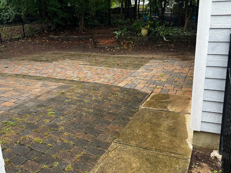 stained, uneven paver patio beside the side door of the house before concrete replacement in huntersville, nc