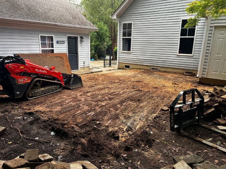 compact track loader removing old pavers and regrading the patio area in huntersville, nc