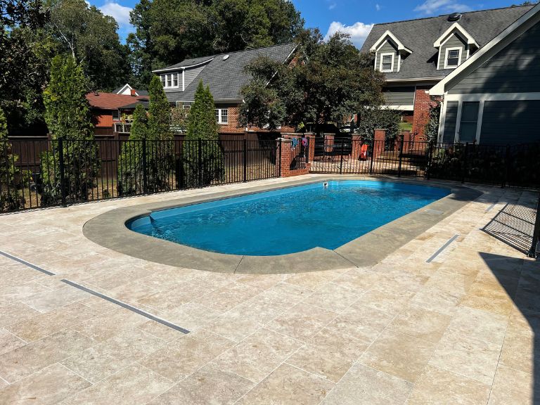 travertine pool deck with linear channel drains facing the house in grier heights, charlotte, nc
